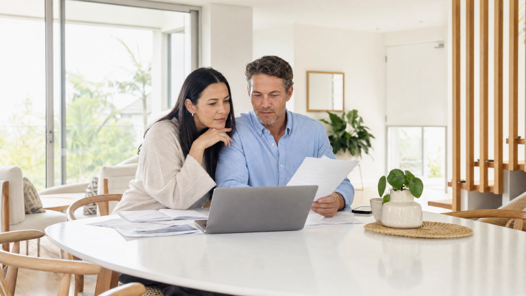 Couple reviewing home loan refinancing documents together at a bright modern Australian home