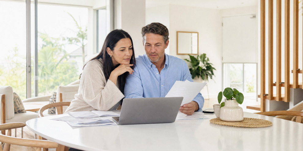 Couple reviewing home loan refinancing documents together at a bright modern Australian home